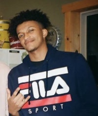 two young men standing next to each other in a kitchen