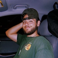 a man in a green shirt sitting in a car